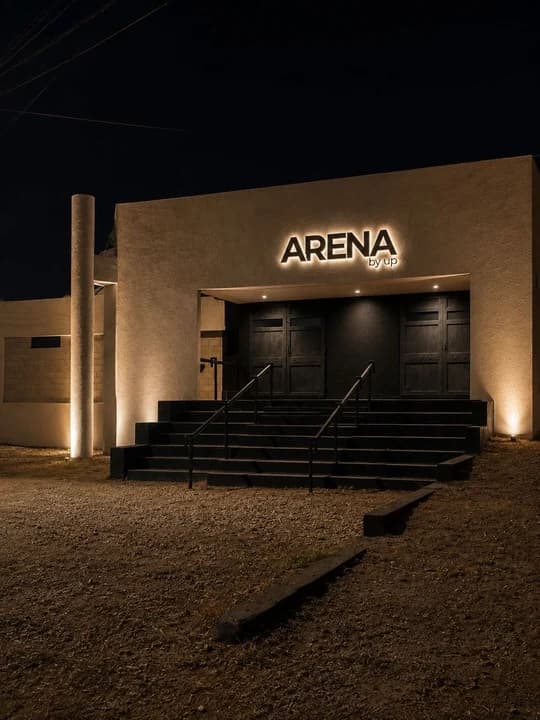 La fachada de ARENA de noche, con el letrero prendido