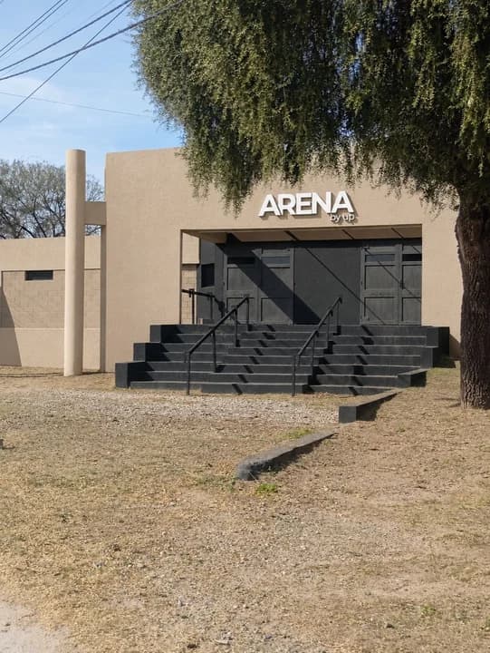 La entrada de ARENA de día, con la grava y el árbol